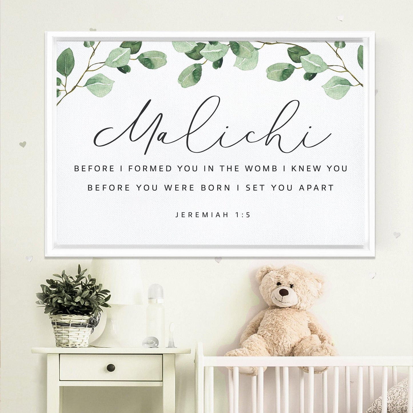 a nursery setting with a framed Bible verse, a teddy bear, and a potted plant.