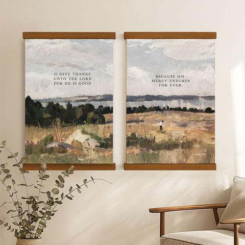 two framed paintings hanging on a wall, depicting a serene landscape with a person walking in the distance.