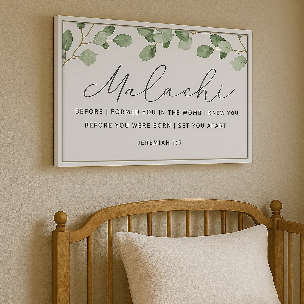a wooden crib with a white pillow on it, and above it is a framed print with a green leaf design and text.