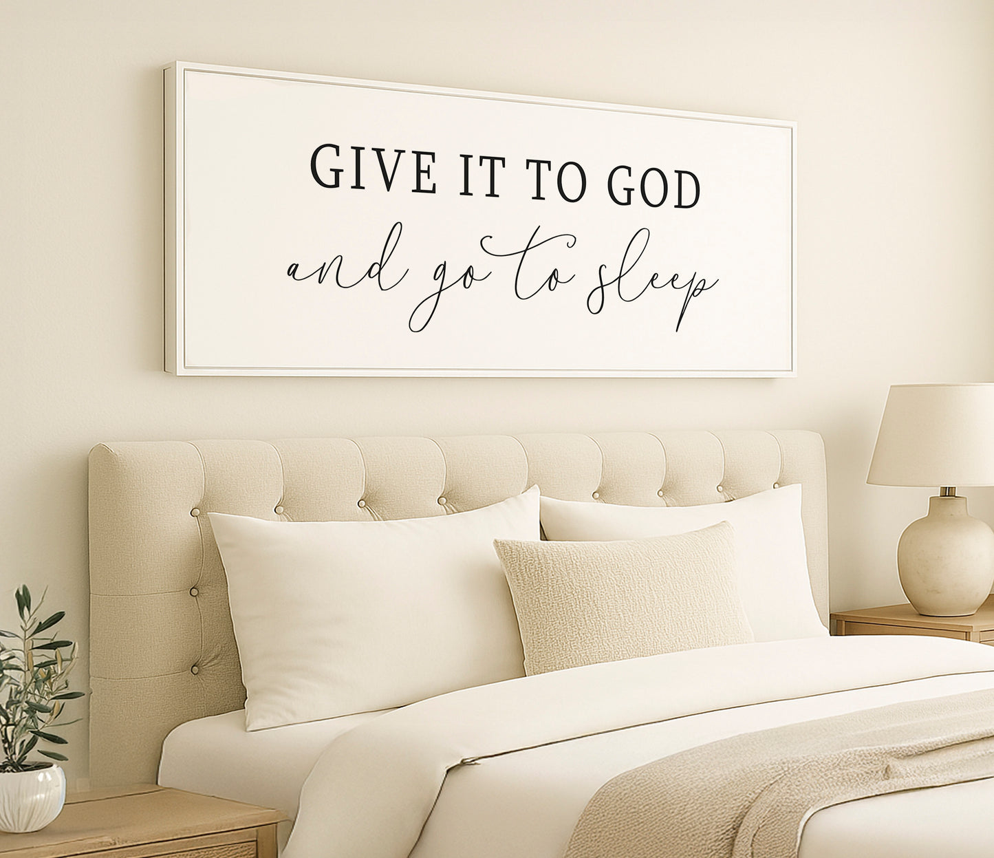 a bedroom with a white bed and a framed sign above it