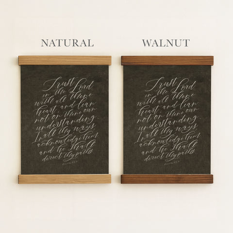 two framed pieces of artwork, each with a black background and white cursive text. The text appears to be a religious or biblical passage, and the artwork is framed in two different wood types, with one being natural and the other being walnut.