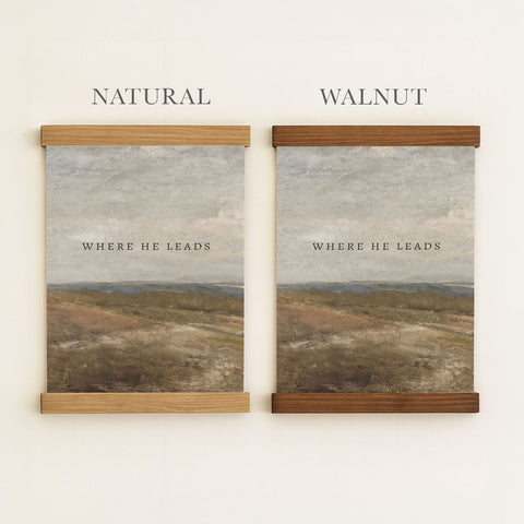 two framed prints of the same landscape, one with a natural wood frame and the other with a walnut frame.