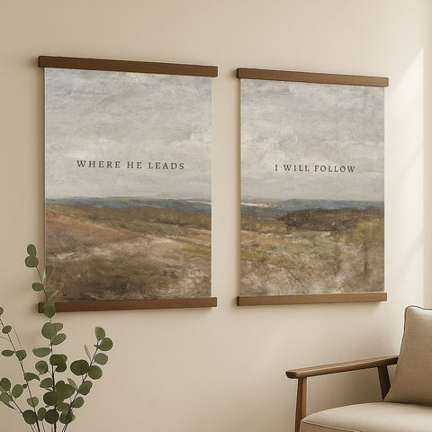 two framed paintings hanging on a wall, each depicting a landscape scene. The text on the paintings reads