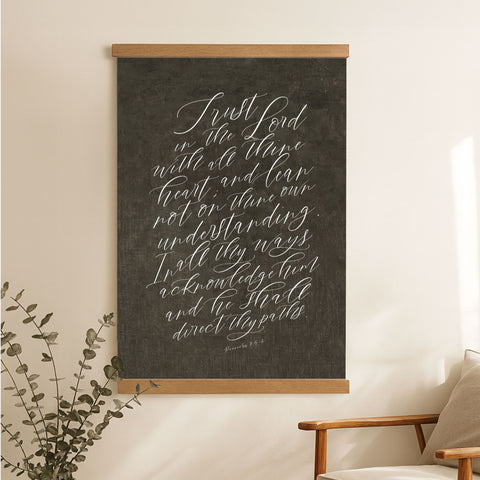 a blackboard with white handwritten text, hanging on a wall next to a wooden chair.