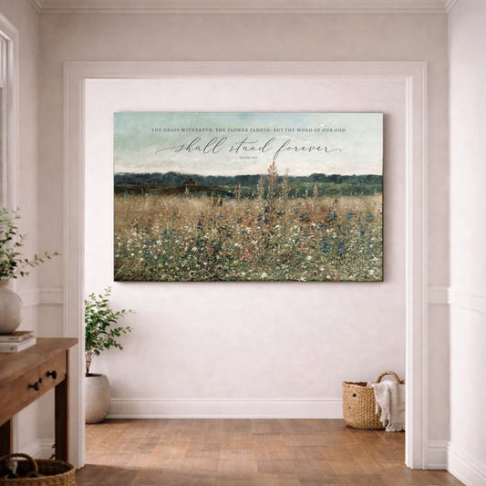 a large canvas print of a pastoral landscape with a field of flowers, hanging on a white wall in a room with a wooden floor.