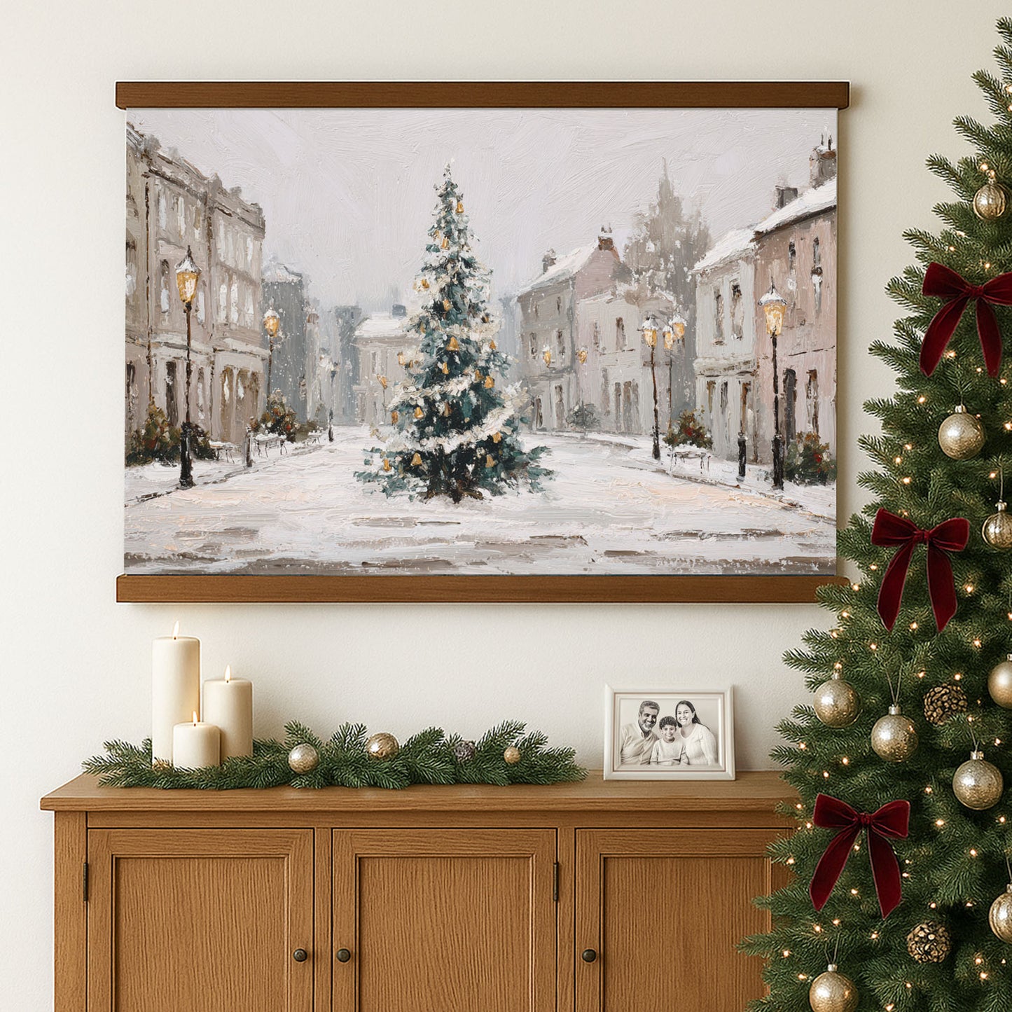a large painting of a snowy street scene with a Christmas tree in the center, hanging on a wall above a wooden cabinet with a family portrait and Christmas decorations.