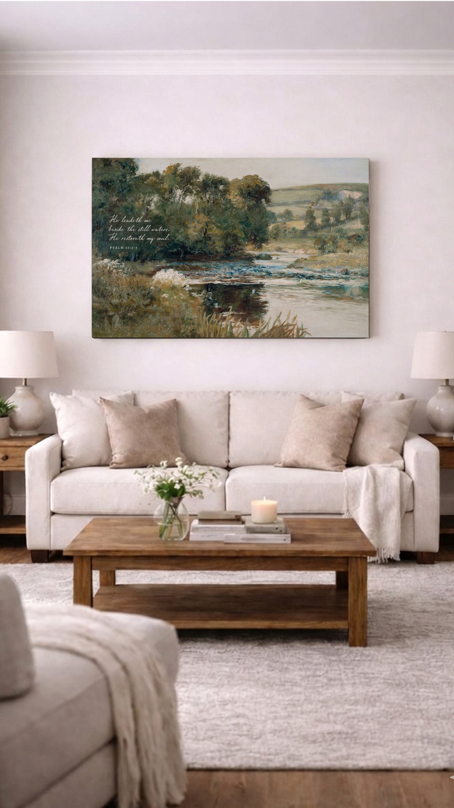 a cozy living room with a large painting of a serene landscape hanging on the wall above a beige sofa and a wooden coffee table. The room is decorated with a vase of flowers, a candle, and a book, creating a warm and inviting atmosphere.