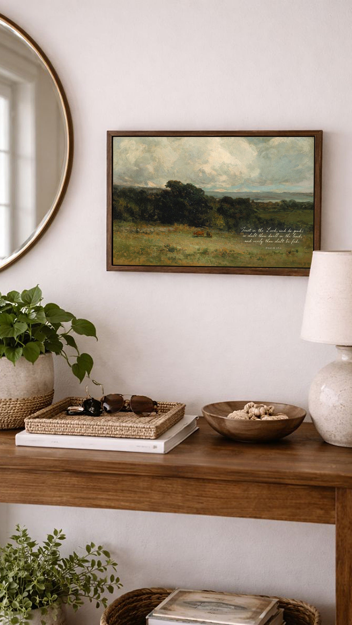 a wooden console table with various decorative items and a framed landscape painting hanging on the wall above it.