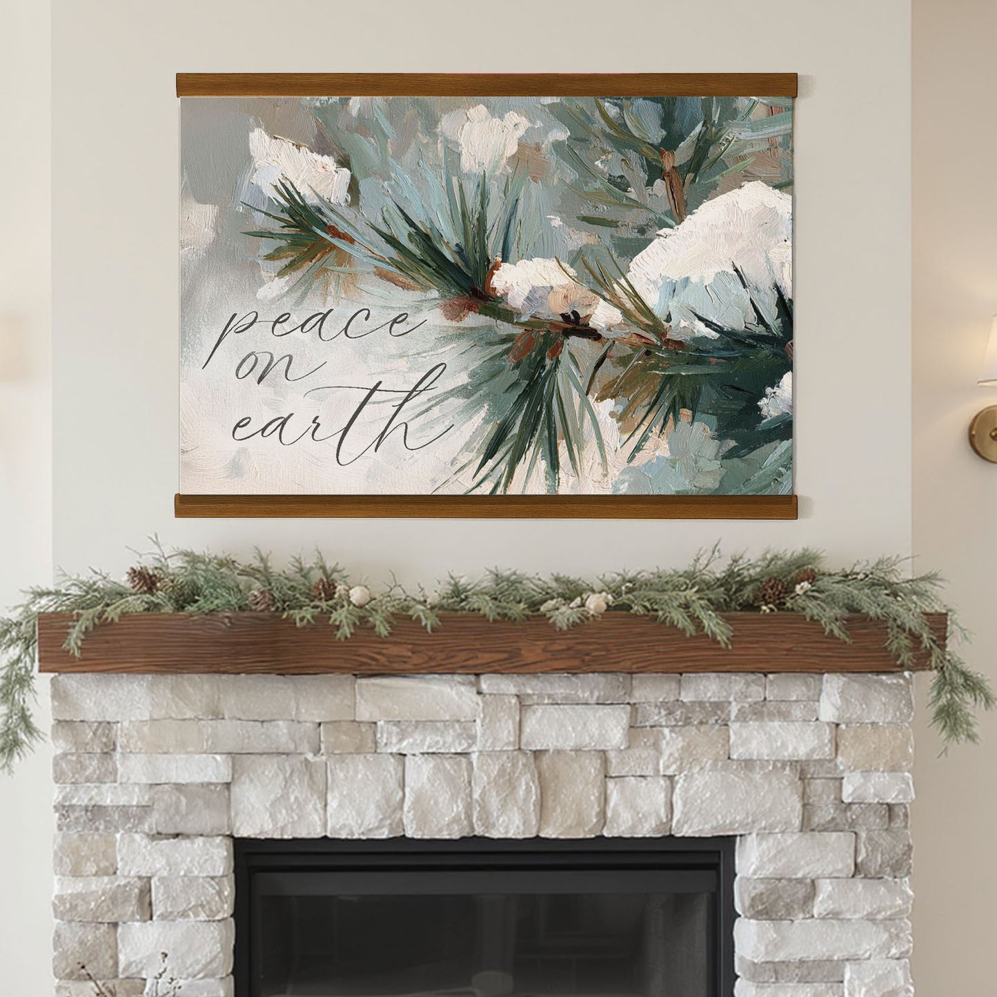 a fireplace mantel decorated with greenery and pine branches, with a framed painting hanging above it. The painting depicts a snowy pine tree branch with pine needles. The text "Peace on earth" is written on the painting.