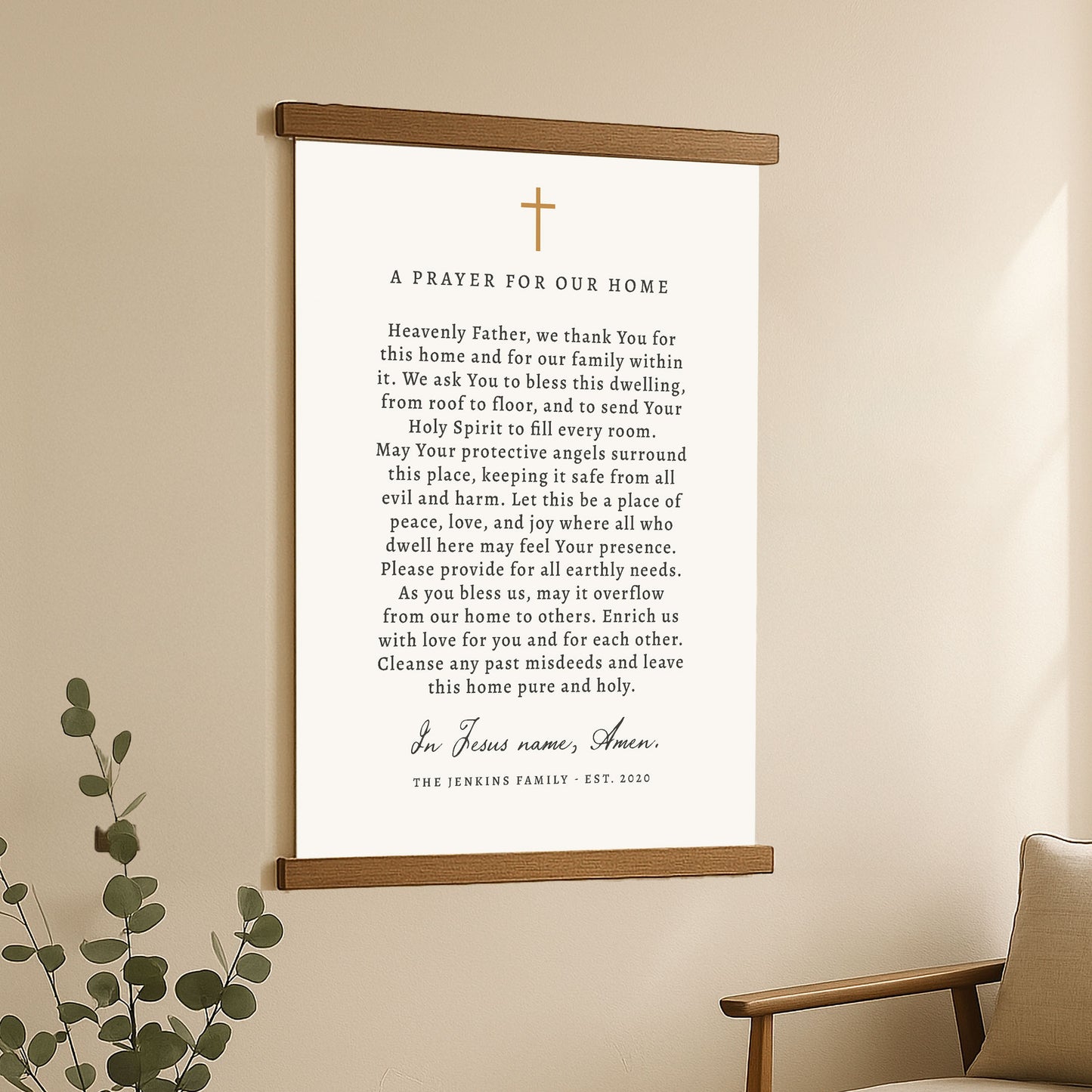 A framed prayer for our home with a cross and a plant in the background.