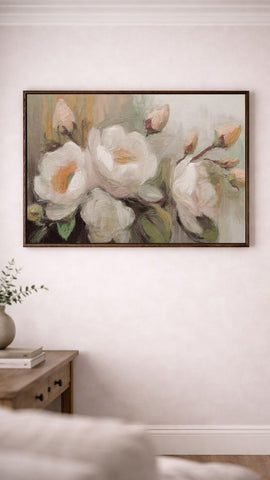 a large painting of white flowers hanging on a wall above a wooden table.