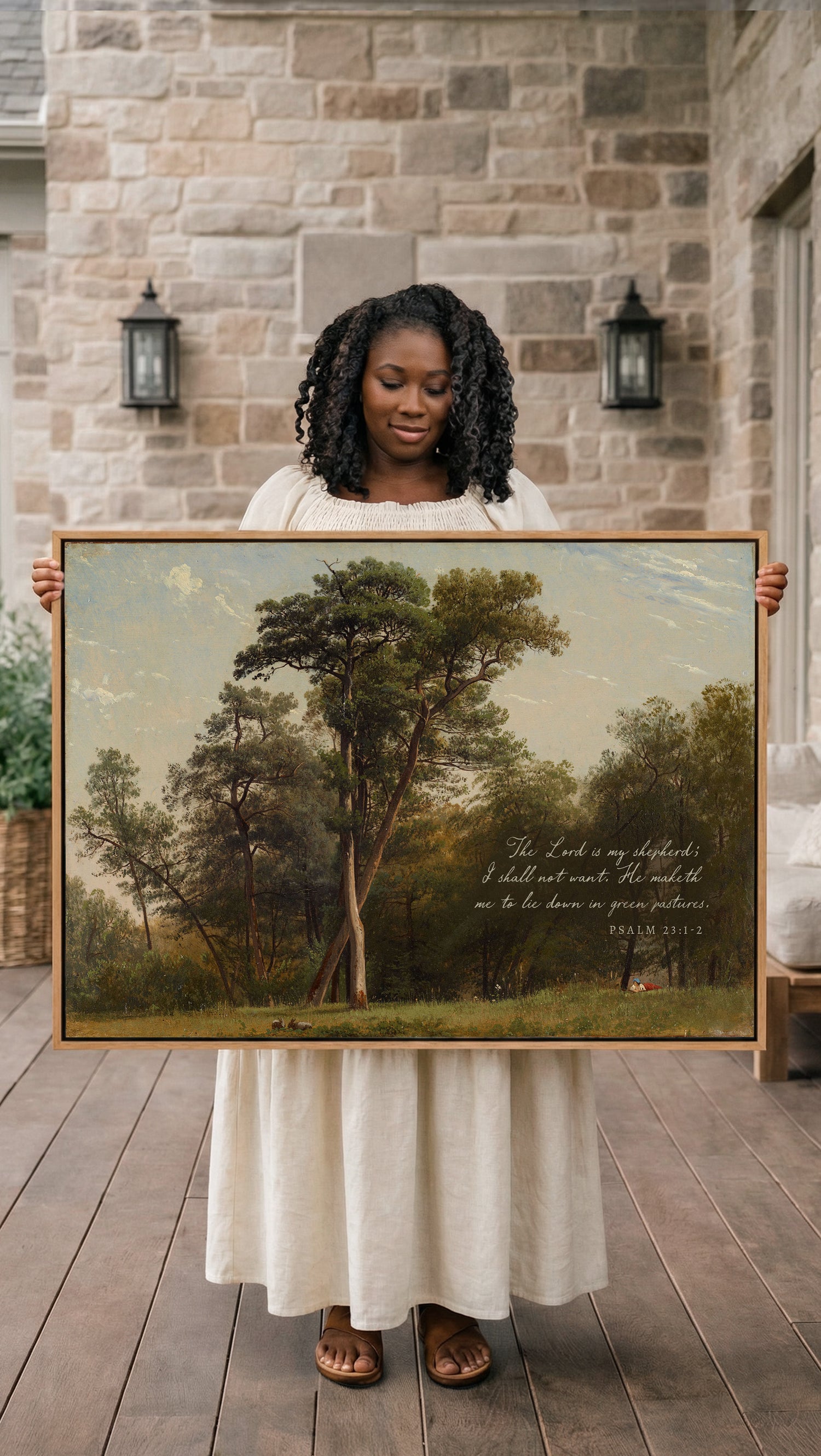 A woman in a white dress holds a large painting of a forest scene, with a Bible verse visible in the painting.
