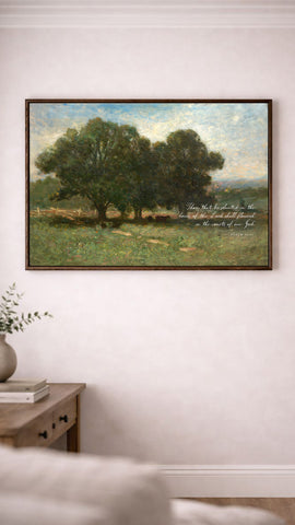 a painting of a serene landscape with a group of trees in the foreground and a peaceful countryside in the background. The painting is hung on a white wall above a wooden table with a vase of flowers on it.