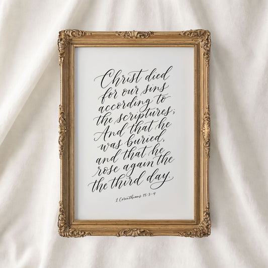 a framed print with a hand-lettered Bible verse from 1 Corinthians 15:3-4.