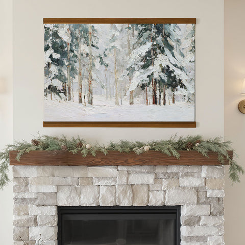 a fireplace with a painting of a snowy forest hanging above it. The painting is framed and mounted on the wall above the fireplace.