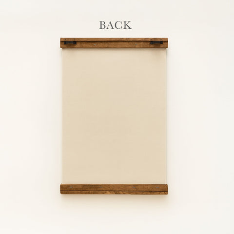a wooden frame with a blank canvas or paper inside, mounted on a white wall.