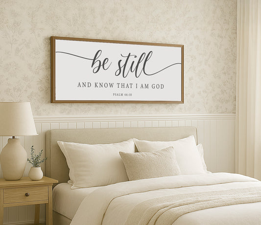 a bed with a white comforter and a wooden framed sign above it