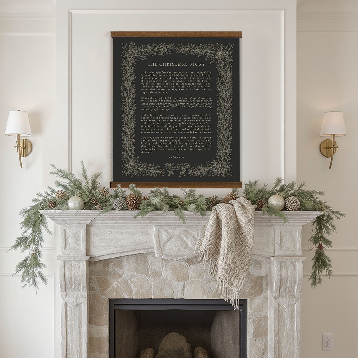 a fireplace decorated with greenery, pine cones, and ornaments, with a framed black and white poster of a Christmas story hanging above it.