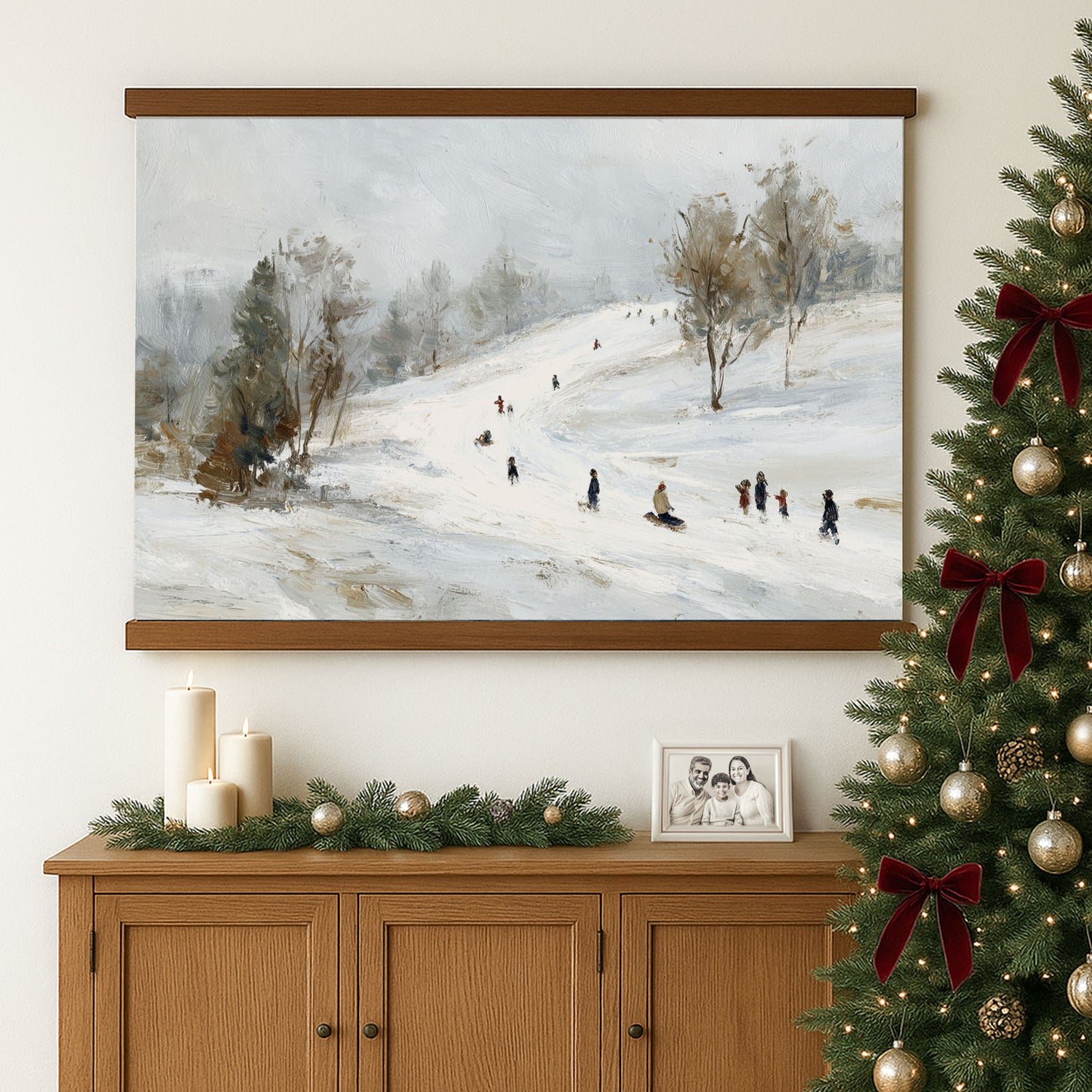 a cozy Christmas scene with a framed painting of people skiing on a snowy hill, a decorated Christmas tree, and a wooden cabinet with holiday decorations.
