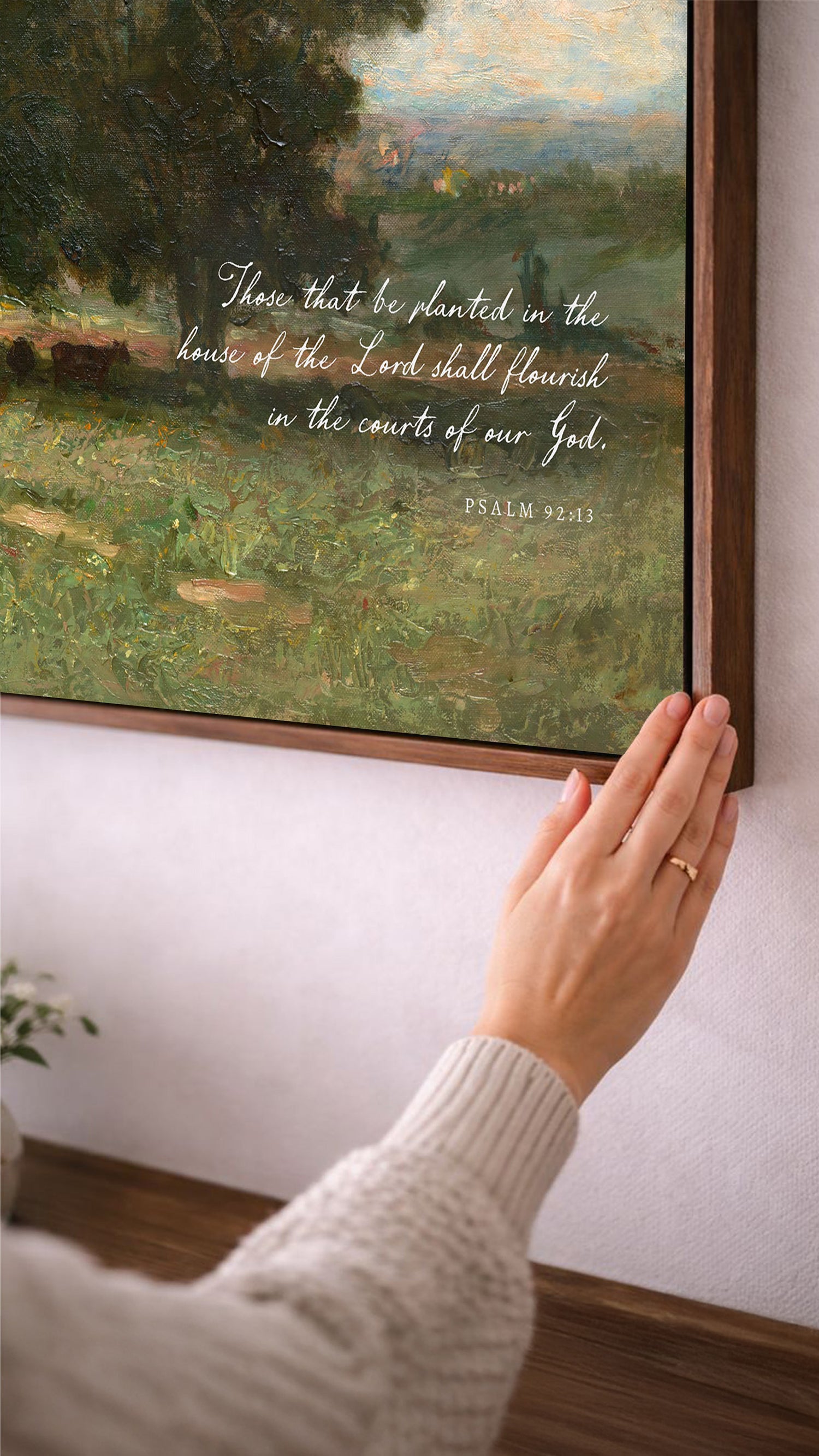 A person's hand is reaching towards a painting of a lush green landscape, with a text overlay that reads "There that be planted in the house of the Lord shall flourish in the courts of our God."