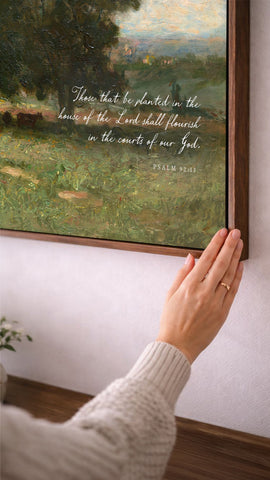A person's hand is reaching towards a painting of a lush green landscape, with a text overlay that reads 