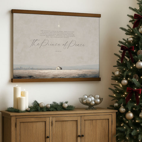 a wooden cabinet with a bowl of silver ornaments and a Christmas tree decorated with red and gold ornaments, with a framed print of a landscape and a Bible verse hanging on the wall above it.