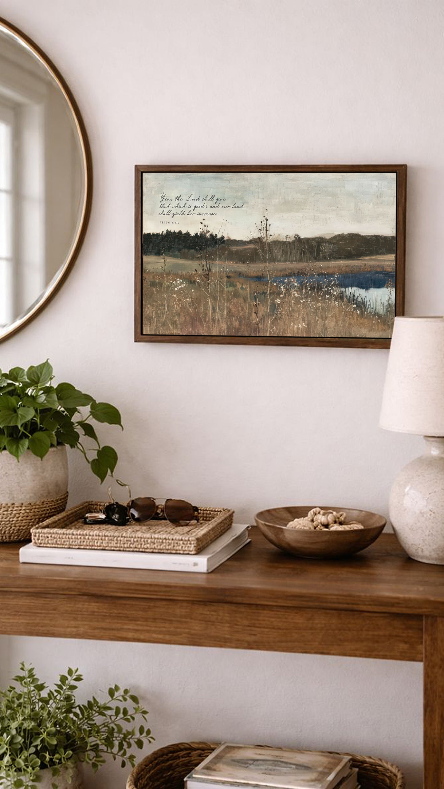a wooden console table with various decorative items and a framed landscape painting hanging on the wall above it.