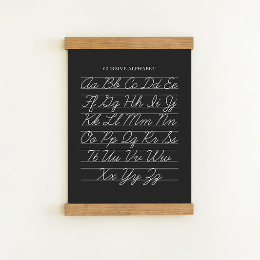 The image is a blackboard with a cursive alphabet written on it.