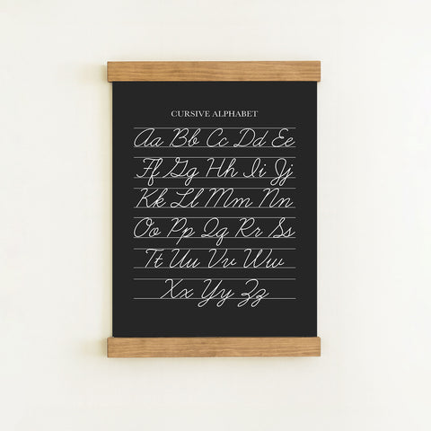 The image is a blackboard with a cursive alphabet written on it.