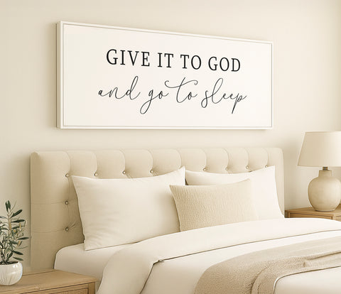 a bedroom with a white bed and a framed sign above it