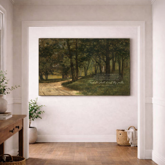 a large painting of a forest scene hanging on a white wall in a room with a wooden floor.
