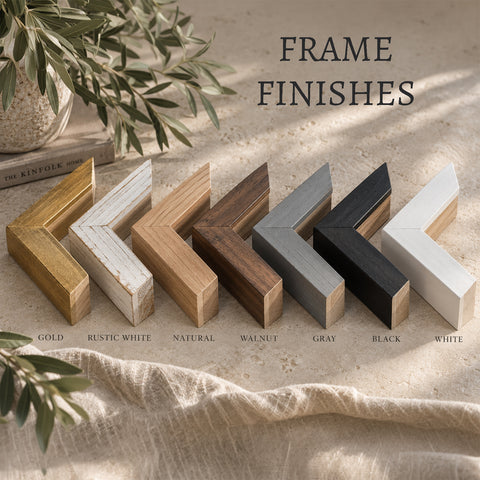 a collection of various wooden frame finishes, including gold, rustic white, natural, walnut, gray, black, and white, arranged in a row on a beige surface.