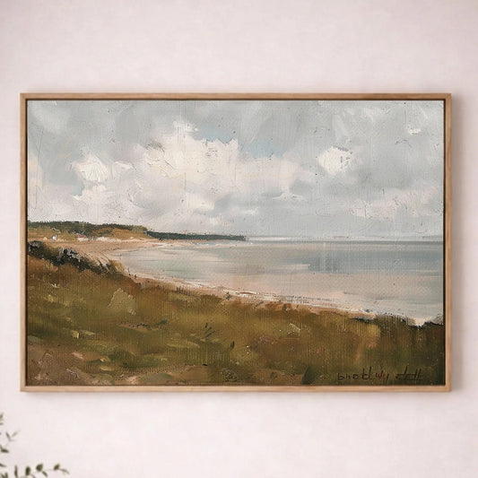 a large landscape painting hanging on a wall, depicting a serene coastal scene with a grassy field and a body of water in the background.
