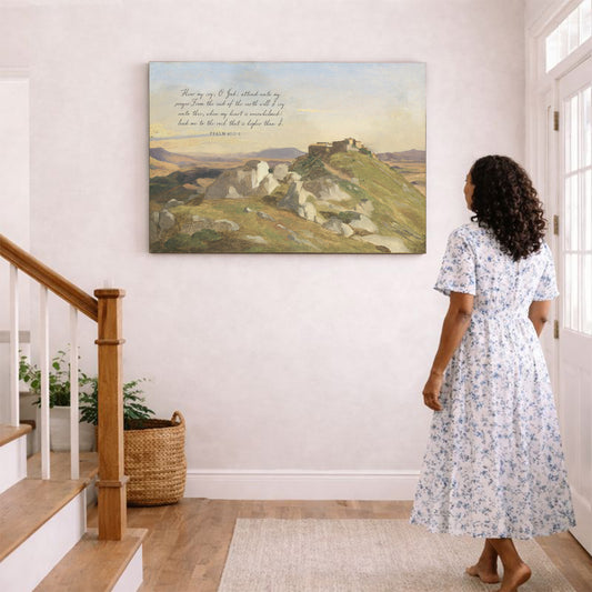 A woman in a blue and white floral dress stands in a hallway, gazing at a painting of a mountainous landscape hanging on the wall.