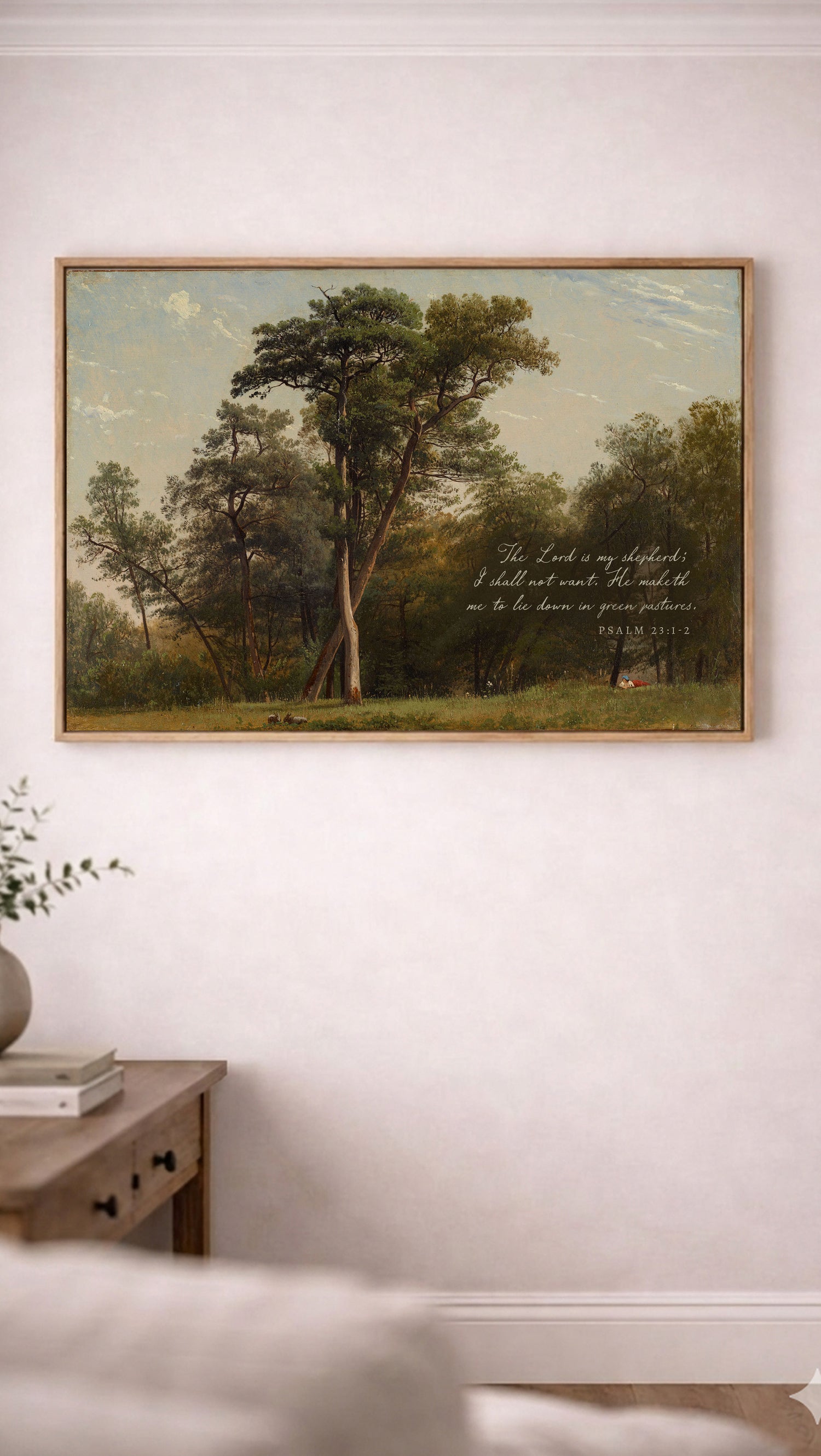a painting of a serene landscape with a large tree in the foreground and a smaller tree in the background, set against a blue sky with clouds. The painting is hung on a white wall above a wooden table with a plant on it.