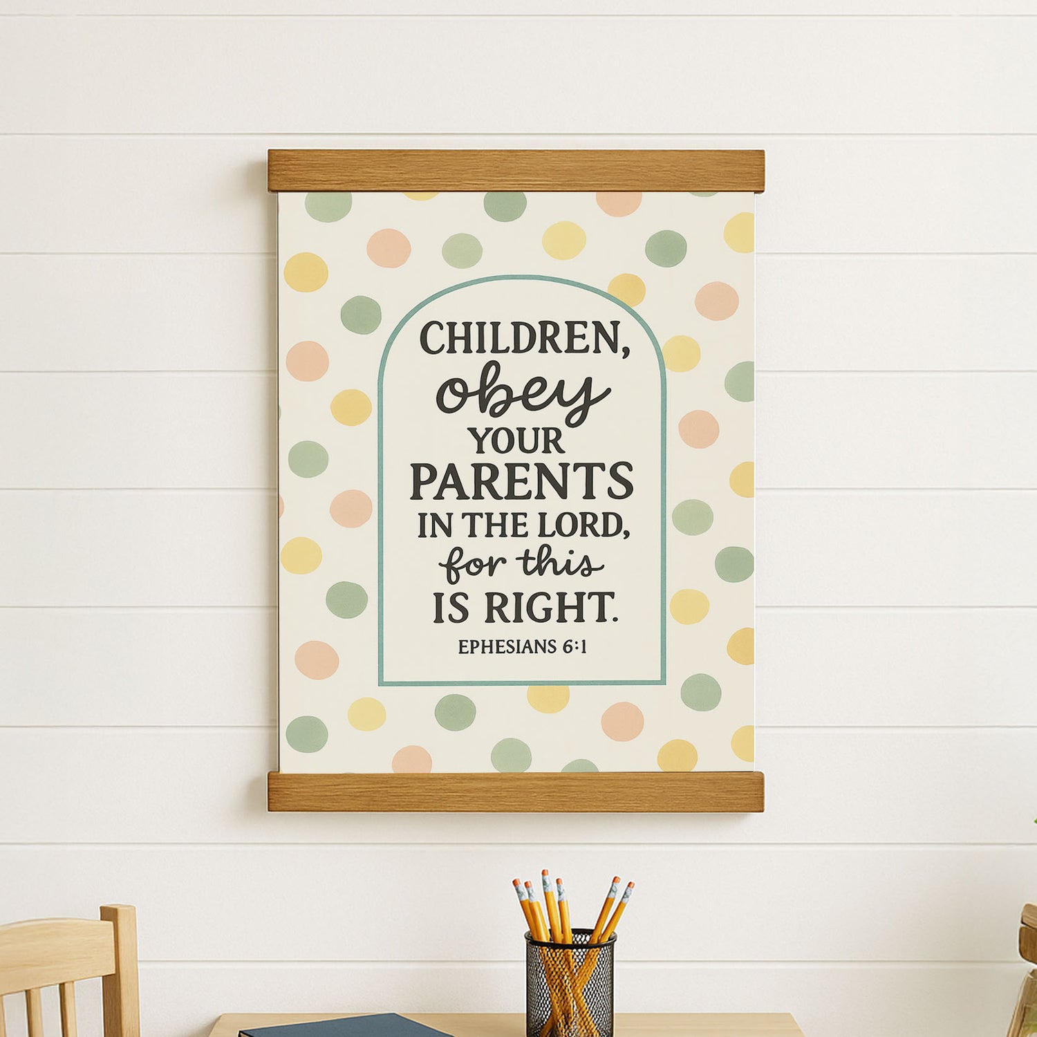 a poster with a Bible verse and a wooden frame, hanging on a white wall.