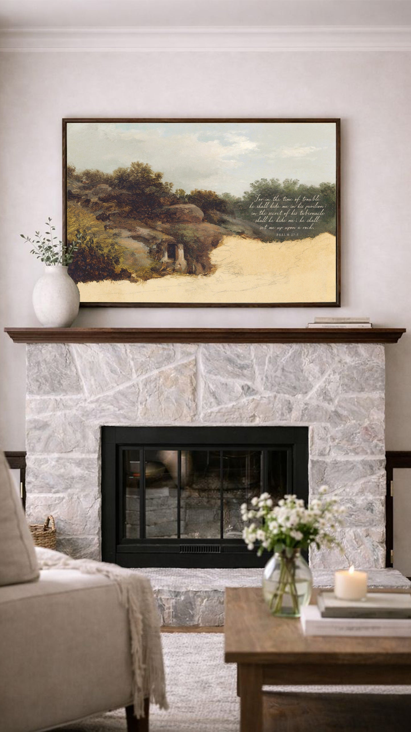 a cozy living room with a stone fireplace, a framed landscape painting above it, and a wooden coffee table with a vase of flowers in the foreground.