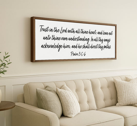 a living room with a couch and a framed quote on the wall