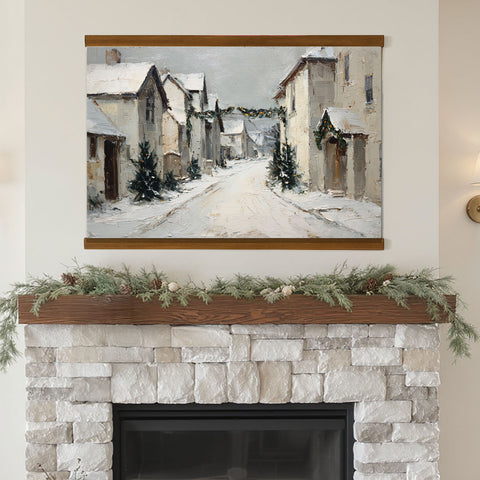 a cozy fireplace with a painting of a snowy village scene hanging above it. The painting depicts a quaint village with snow-covered houses and a winding road, creating a serene and picturesque winter landscape. The fireplace is adorned with a wreath of greenery and pine cones, adding a festive touch to the scene.