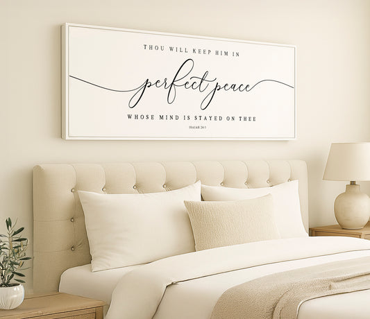 a bedroom with a white bed and a framed picture