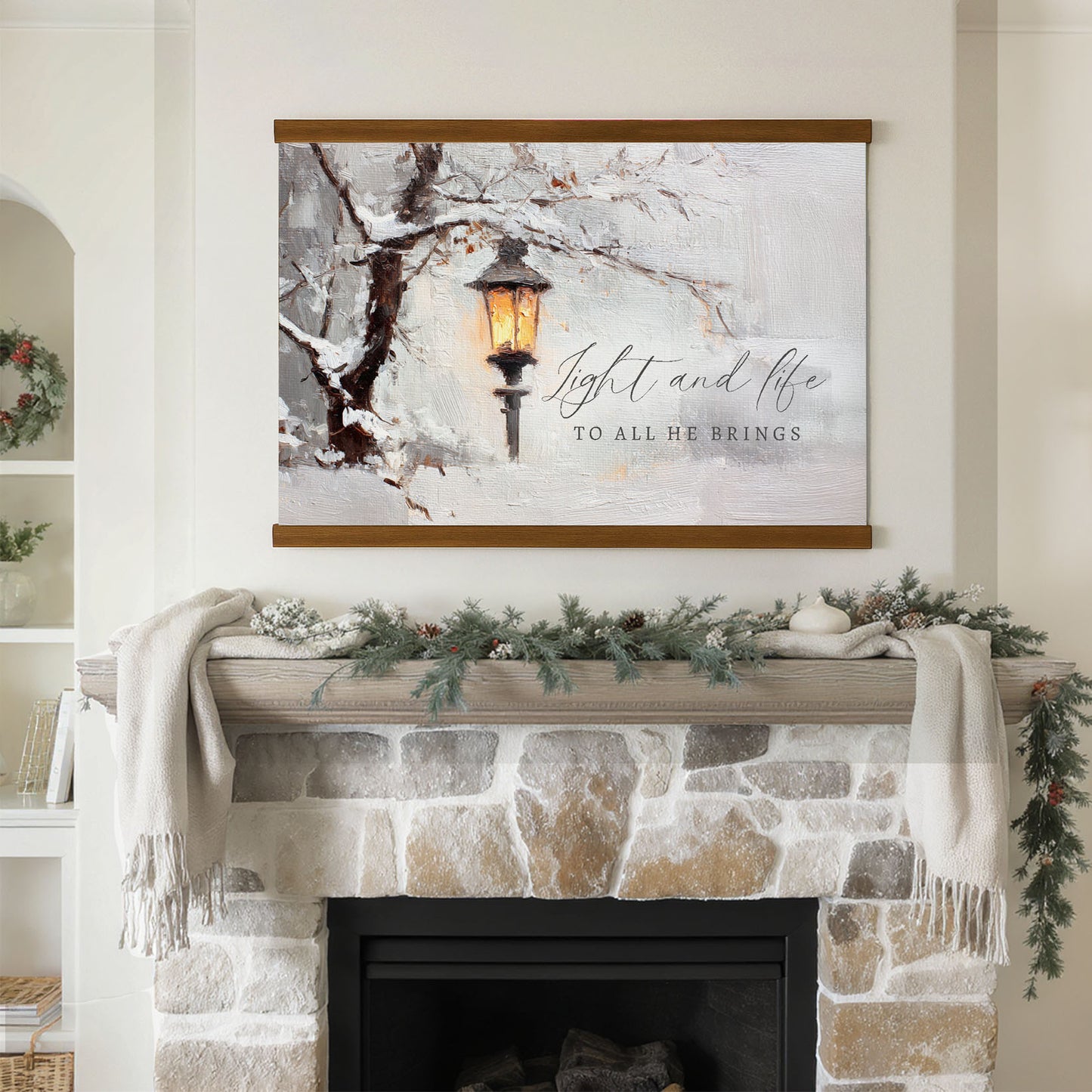 a fireplace mantel decorated with a wreath, pine cones, and a white blanket. Above the mantel is a framed painting depicting a lantern in a snowy landscape.