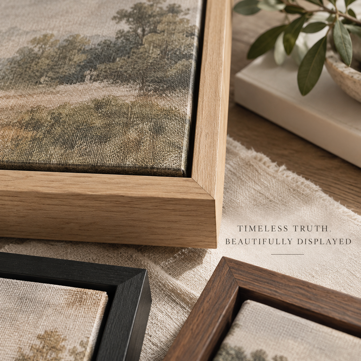 a collection of framed artworks, including a landscape painting and a black and brown wooden frame, all displayed on a wooden surface.