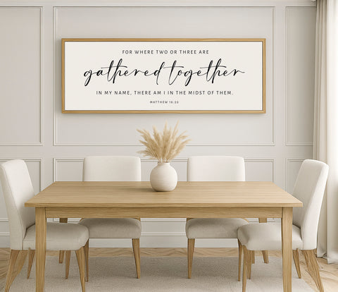 a wooden table with white chairs and a framed quote on the wall
