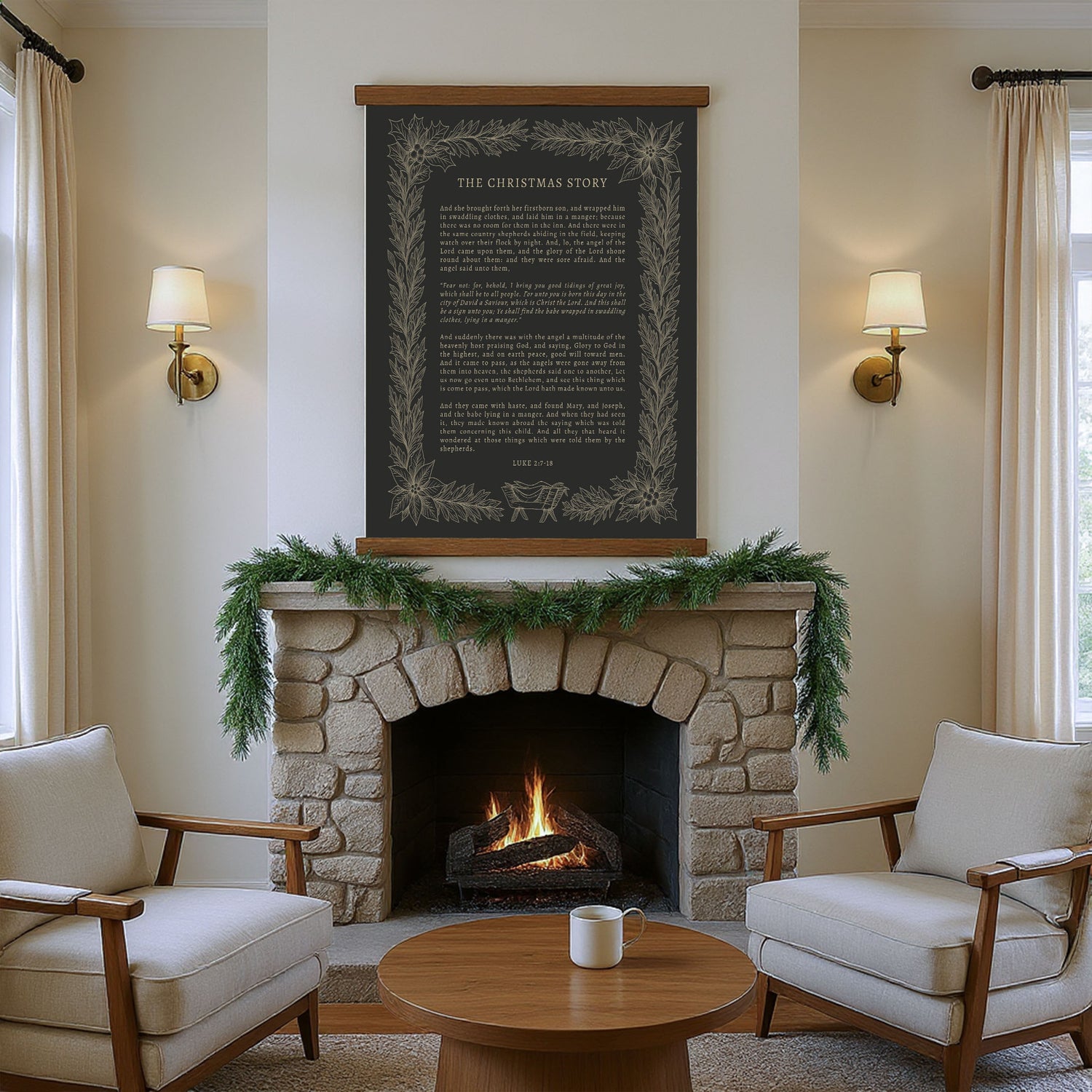 a cozy living room with a stone fireplace, a wooden coffee table, and two beige armchairs arranged around the fireplace. Above the fireplace hangs a black framed poster with a white border and gold lettering, which appears to be a quote or a story. The room is decorated with greenery and a garland, creating a warm and inviting atmosphere.
