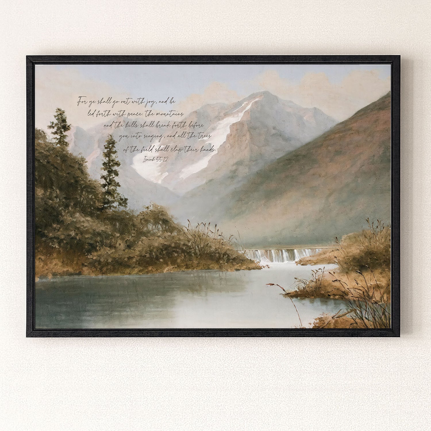 The image is a framed painting depicting a serene mountain landscape with a calm lake or river in the foreground. The mountains in the background are covered in snow, and the sky is a light blue with some clouds. The painting is framed in a black frame and hangs on a wall.