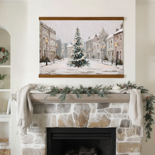 a cozy fireplace decorated for the holiday season, with a large painting of a snowy village scene hanging above it.