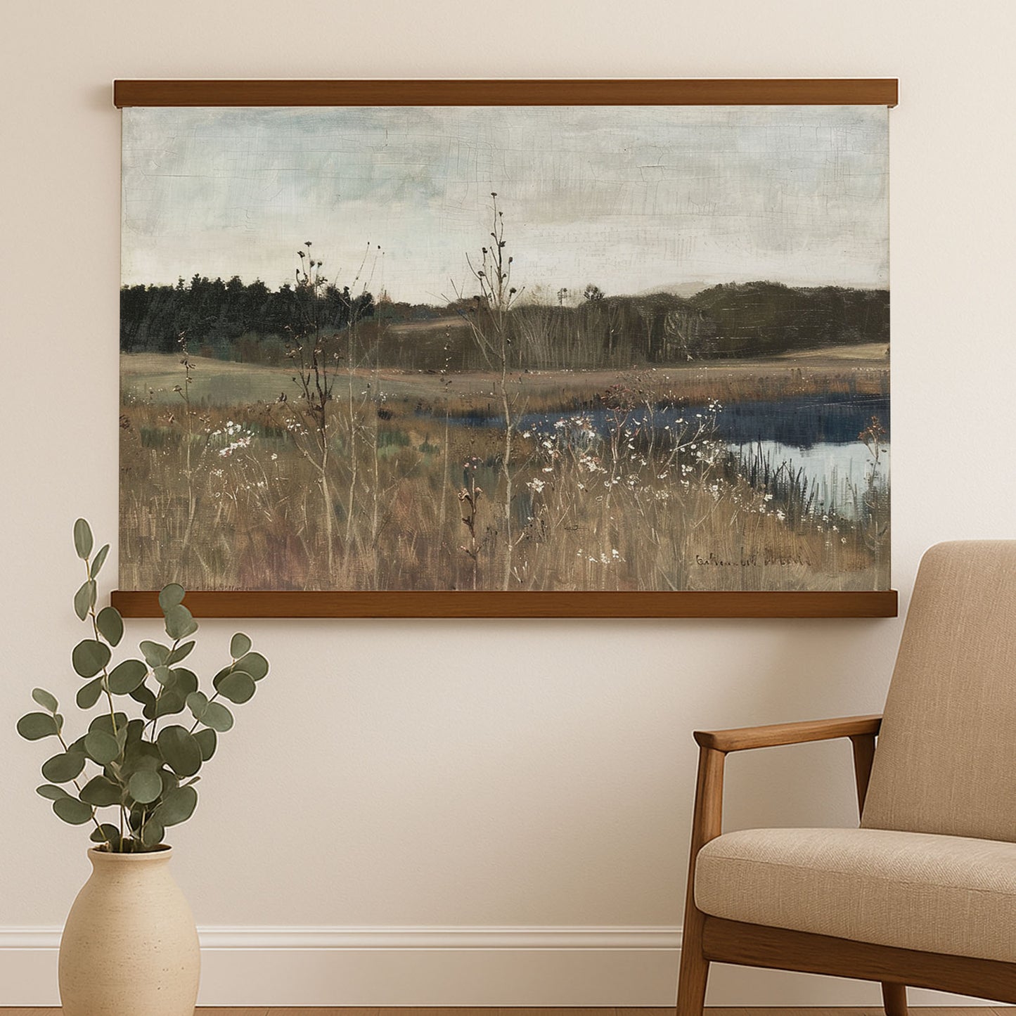 a large landscape painting hanging on a wall, depicting a serene countryside scene with a river and tall grasses. Next to the painting, there is a beige armchair, and a small potted plant is placed on the floor next to the armchair.