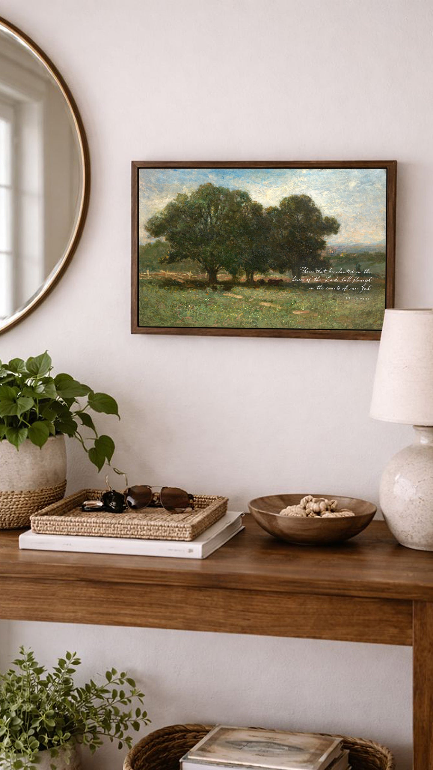 a wooden console table with various decorative items and a framed landscape painting hanging on the wall above it.