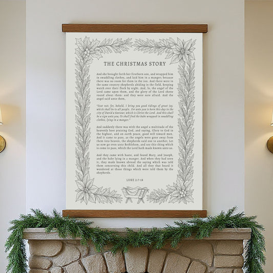 a framed Christmas-themed poster hanging on a wall above a fireplace.