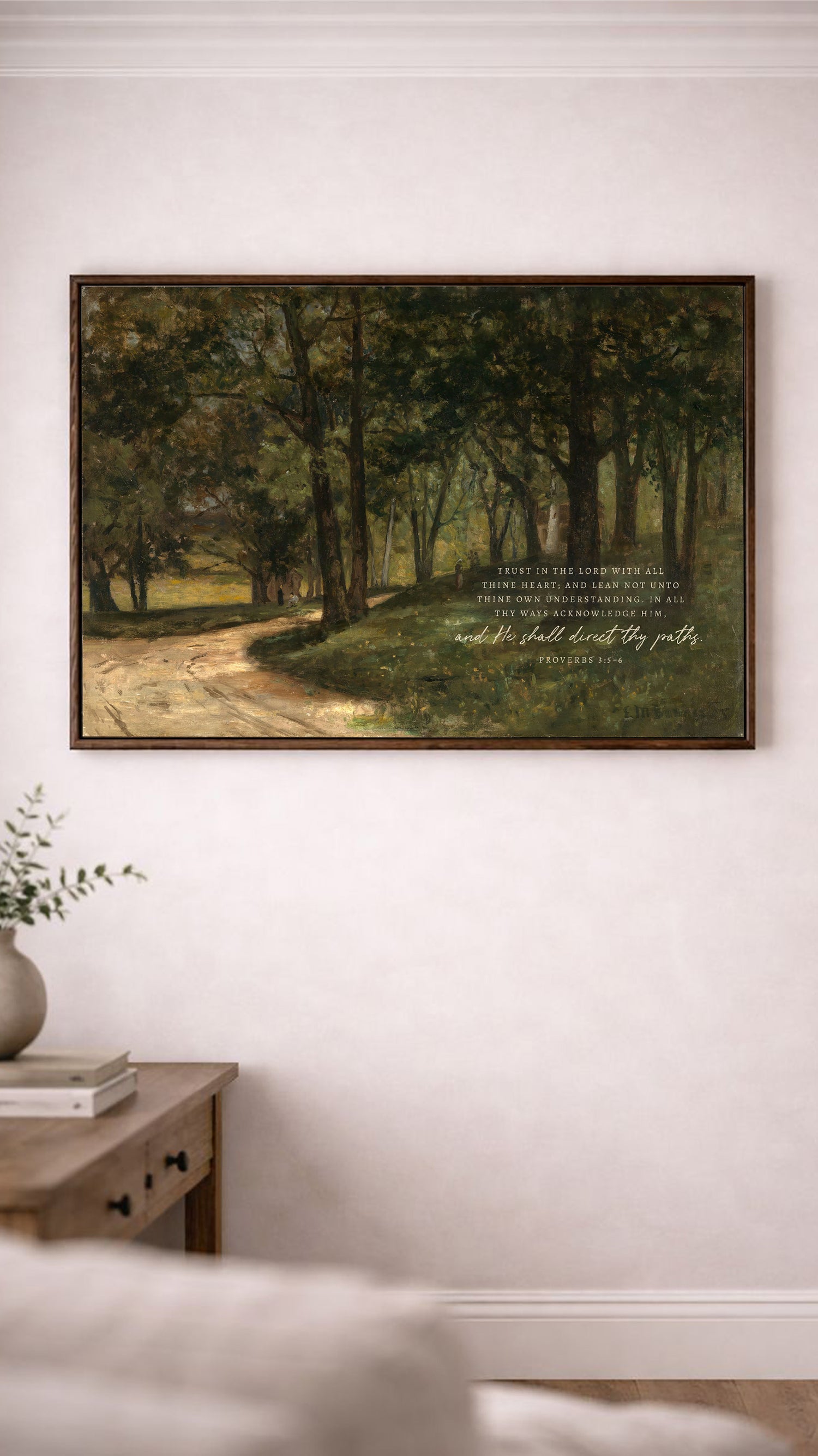 a painting of a forest scene hanging on a white wall, with a quote from the Bible below it.
